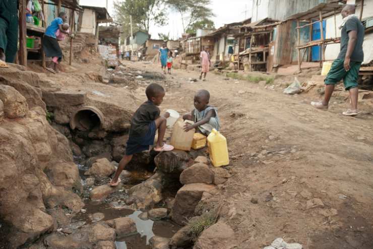 Due bambini raccolgono acqua in strada